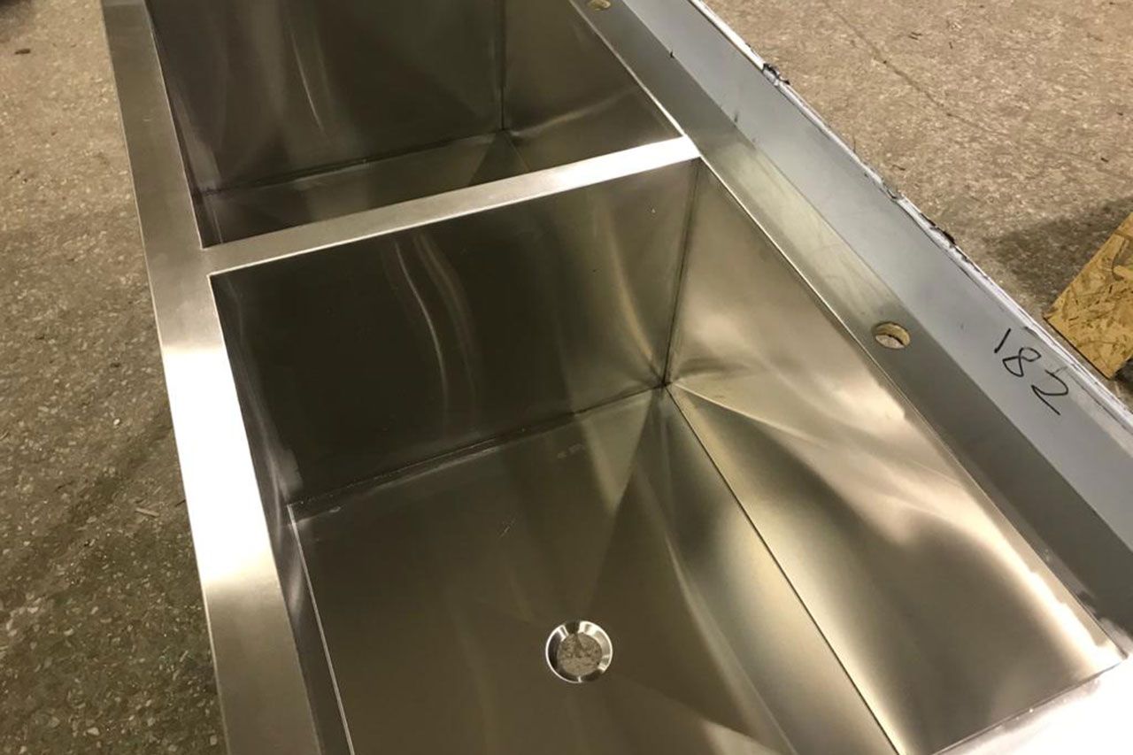 Двухсекционные и односекционные сварные моечные ванны с разуклонкой на дне из нержавеющей стали, с угловым пристенным бортом с трех сторон